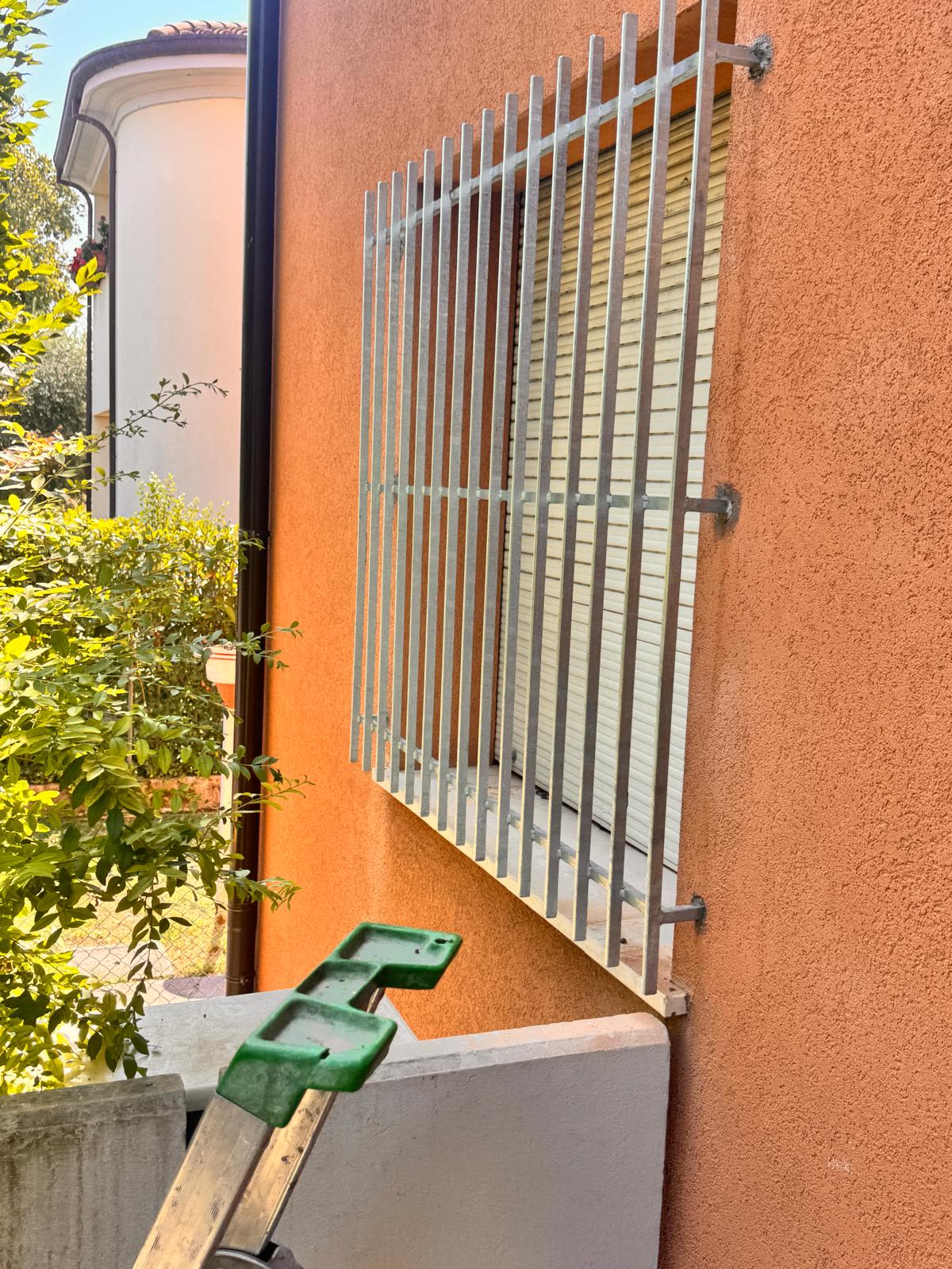 Inferriata zincata ripresa di scorcio, si vedono lo spessore delle barre e il fissaggio a muro